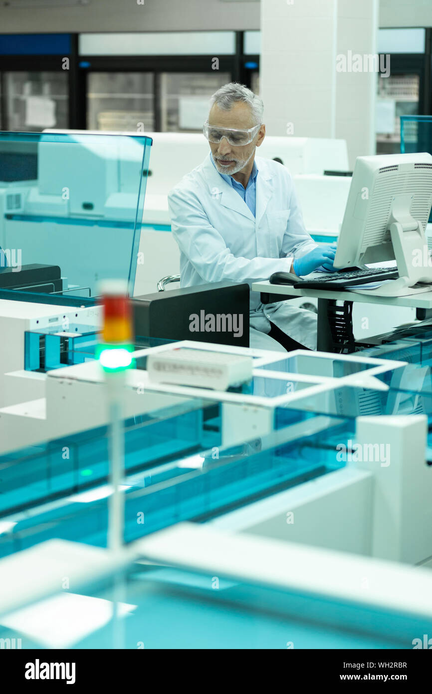 Lieto uomo maturo computer di test in laboratorio Foto Stock