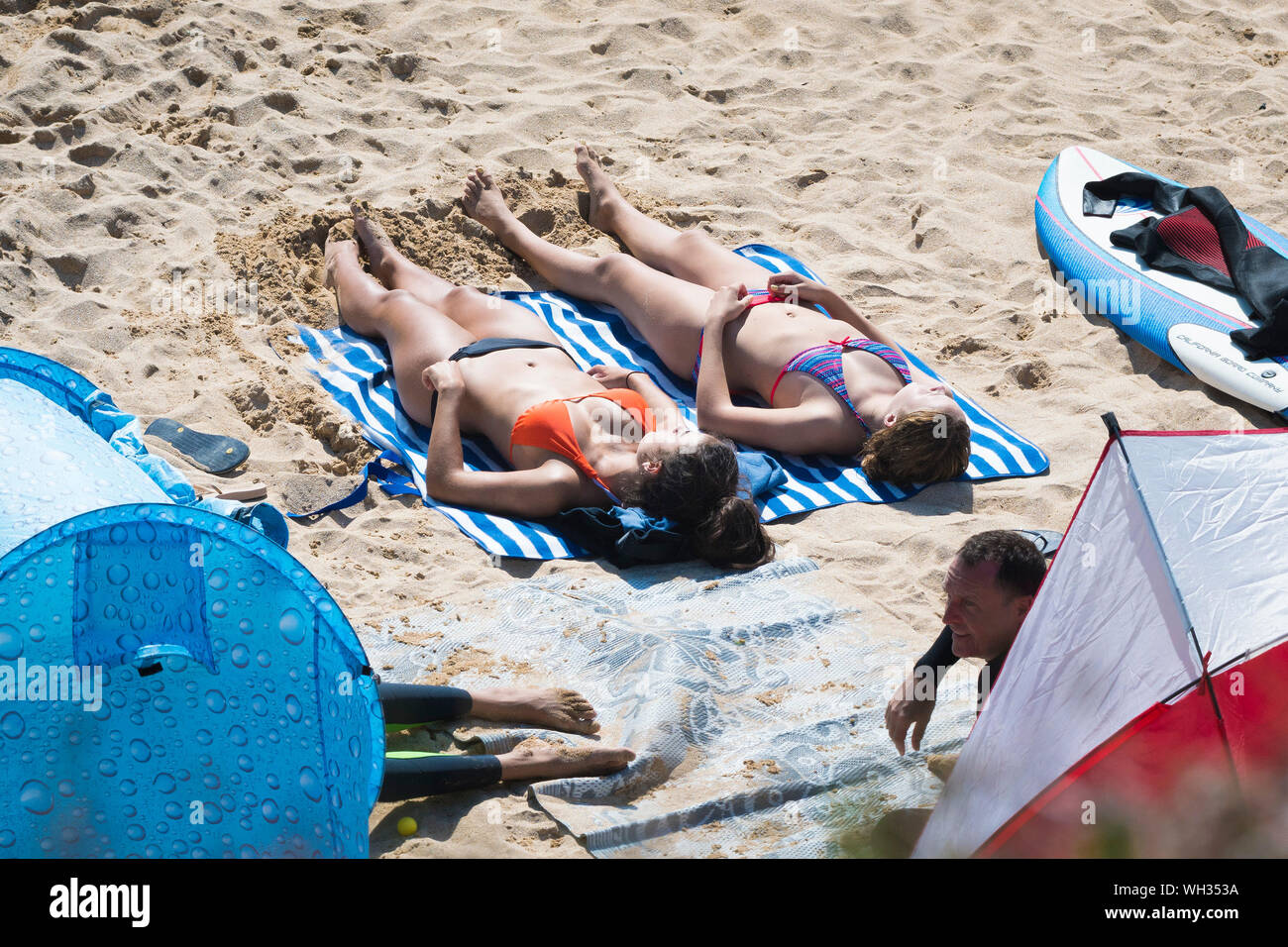 I turisti in vacanza in vacanza al sole sulla Fistral Beach a Newquay in Cornovaglia. Foto Stock