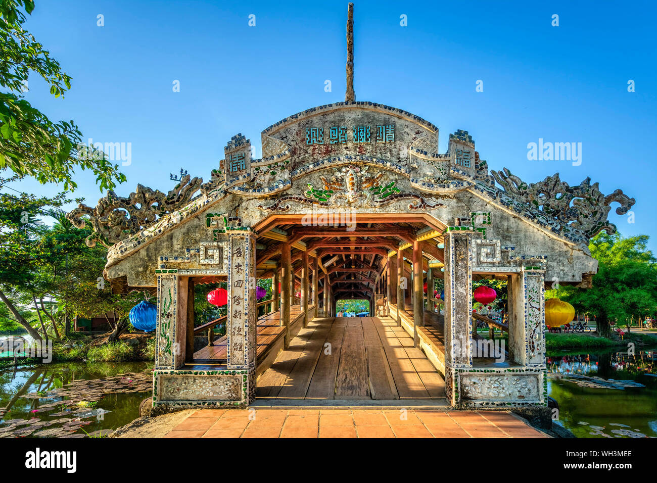 Il Thanh Toan tile bridge. Il vecchio ponte di legno che attraversa il fiume ramo decorato con un alto tetto di tegole risalente al XIX secolo. Hue, Vietnam Foto Stock