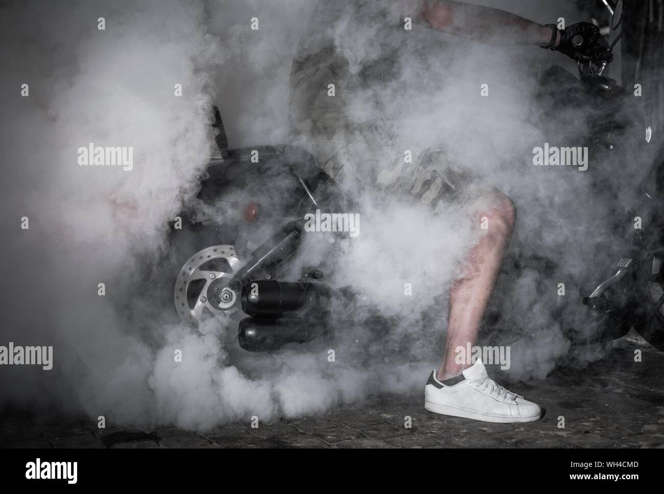 Motocicletta di fumo e Drift Closeup. Potente pneumatico Burnout. Caucasian Bike Rider. Foto Stock