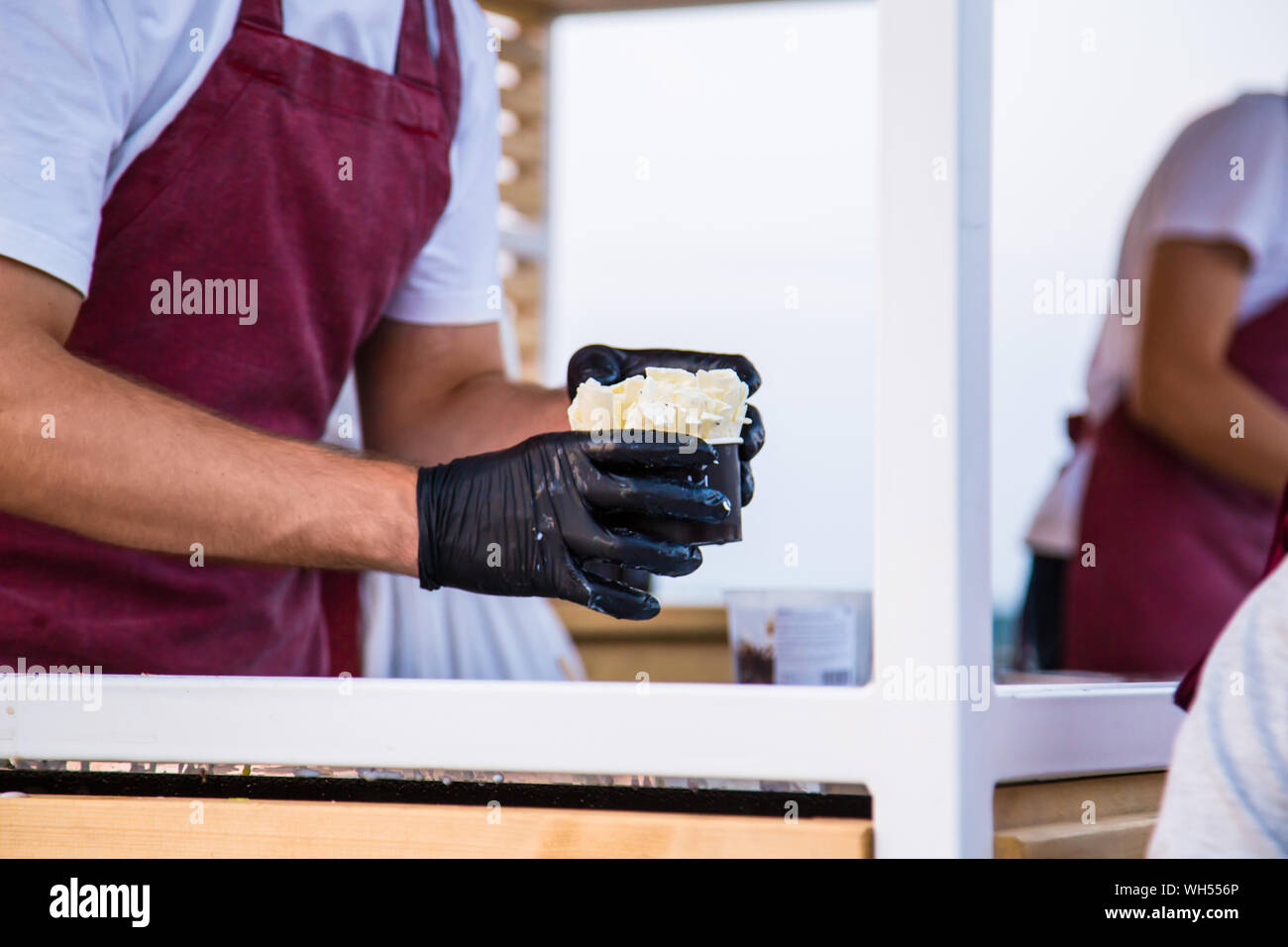 Uomo con il gelato in coppe di nero Foto Stock
