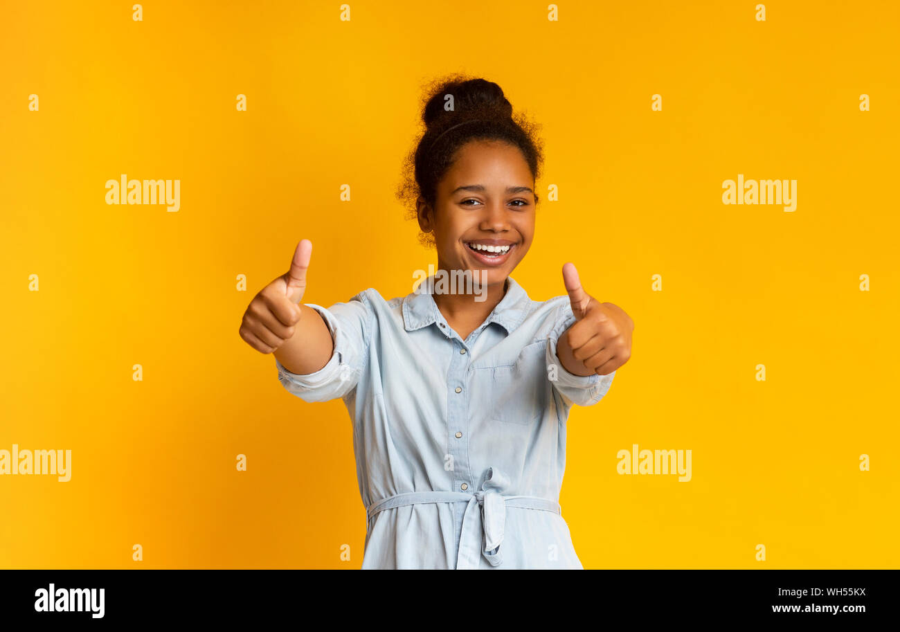 Allegro African American Girl mostra pollice in alto Foto Stock