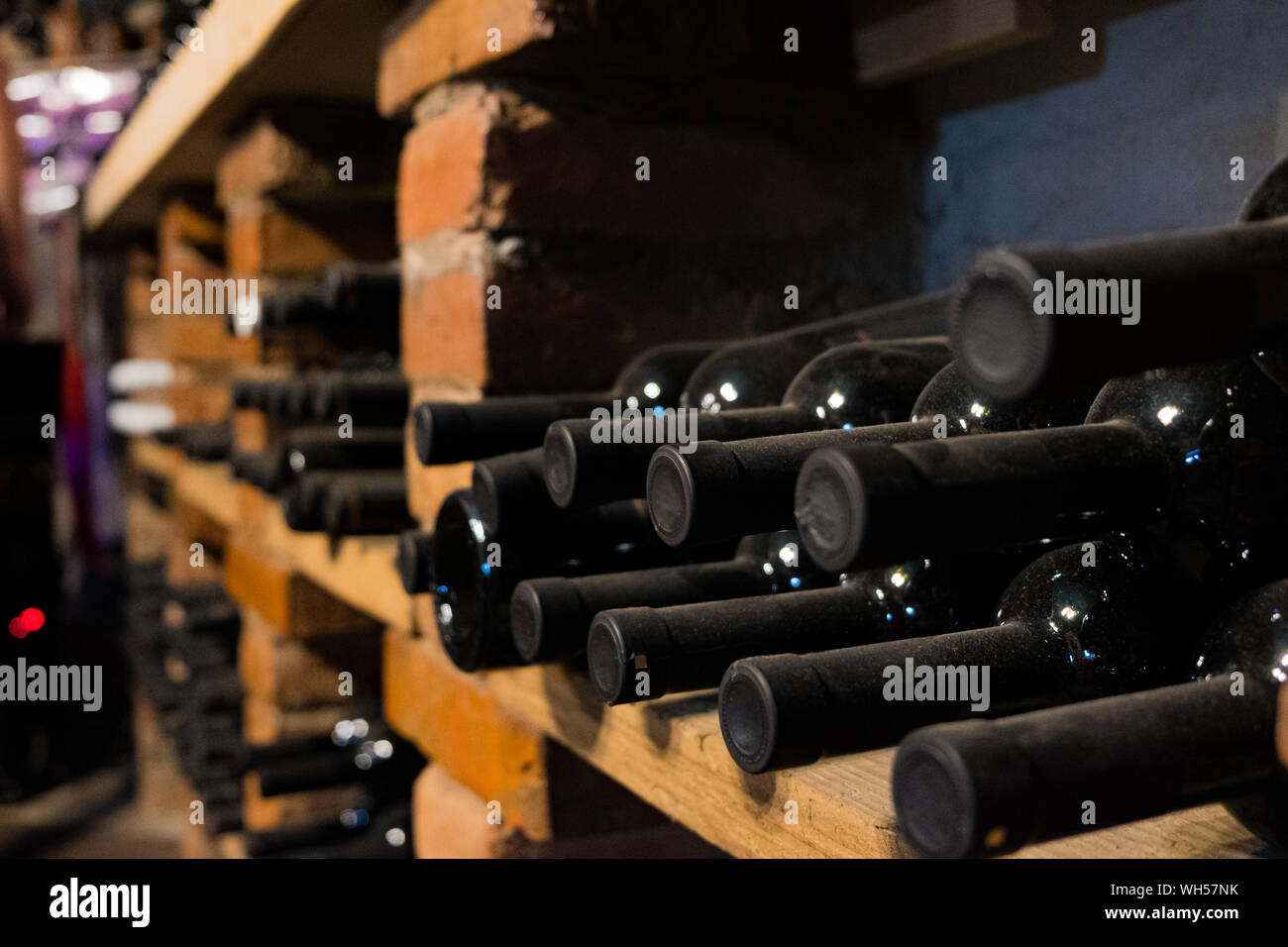 Bottiglie di vino in una cantina, il fuoco selettivo. Vintage vino tappato in una dim bar o in cantina, vista da vicino Foto Stock