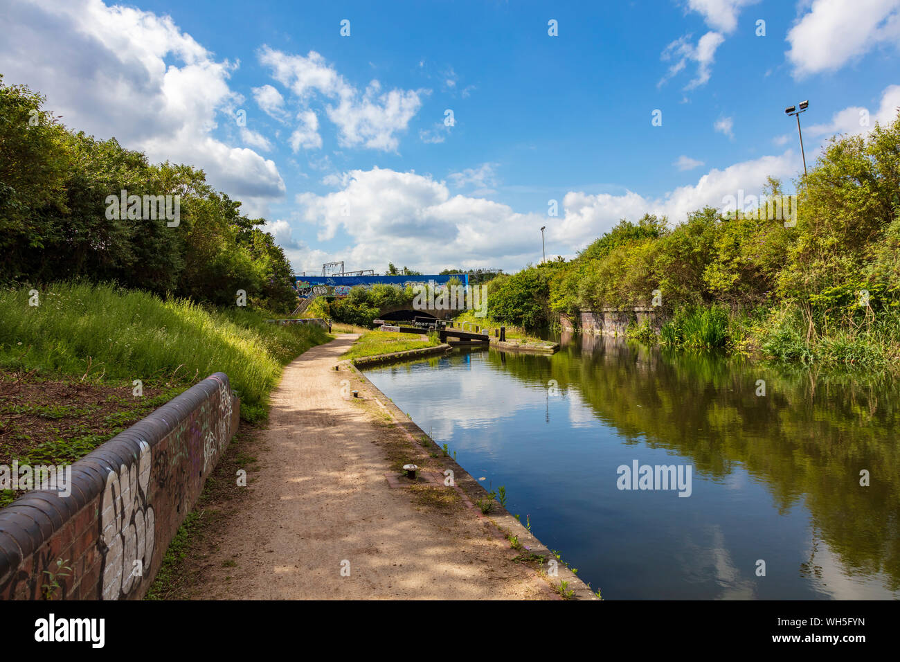 Una vista lungo il ramo di Digbeth Canal verso il Curzon Street Tunnel sotto la linea ferroviaria principale, uno spazio verde con fascino, Birmingham, Regno Unito Foto Stock