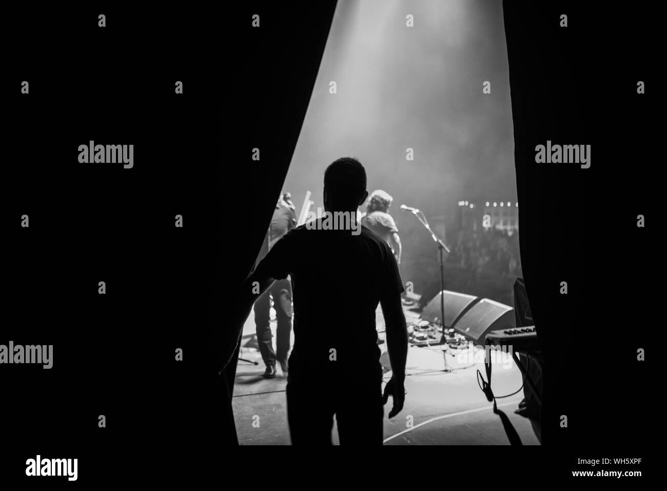 Vista posteriore di Silhouette uomo in piedi sul palco Foto Stock