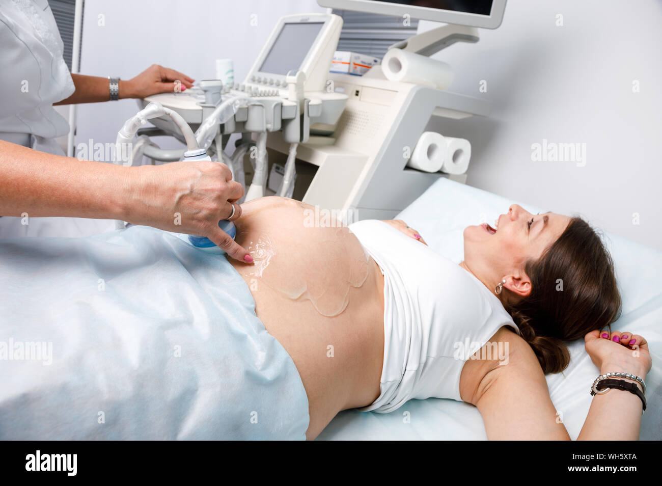 Felice giovane donna incinta con gioia guardando il suo bambino sonogram ha ricevuto una buona notizia ostetrico durante la gravidanza o procedura di ultrasuoni Foto Stock