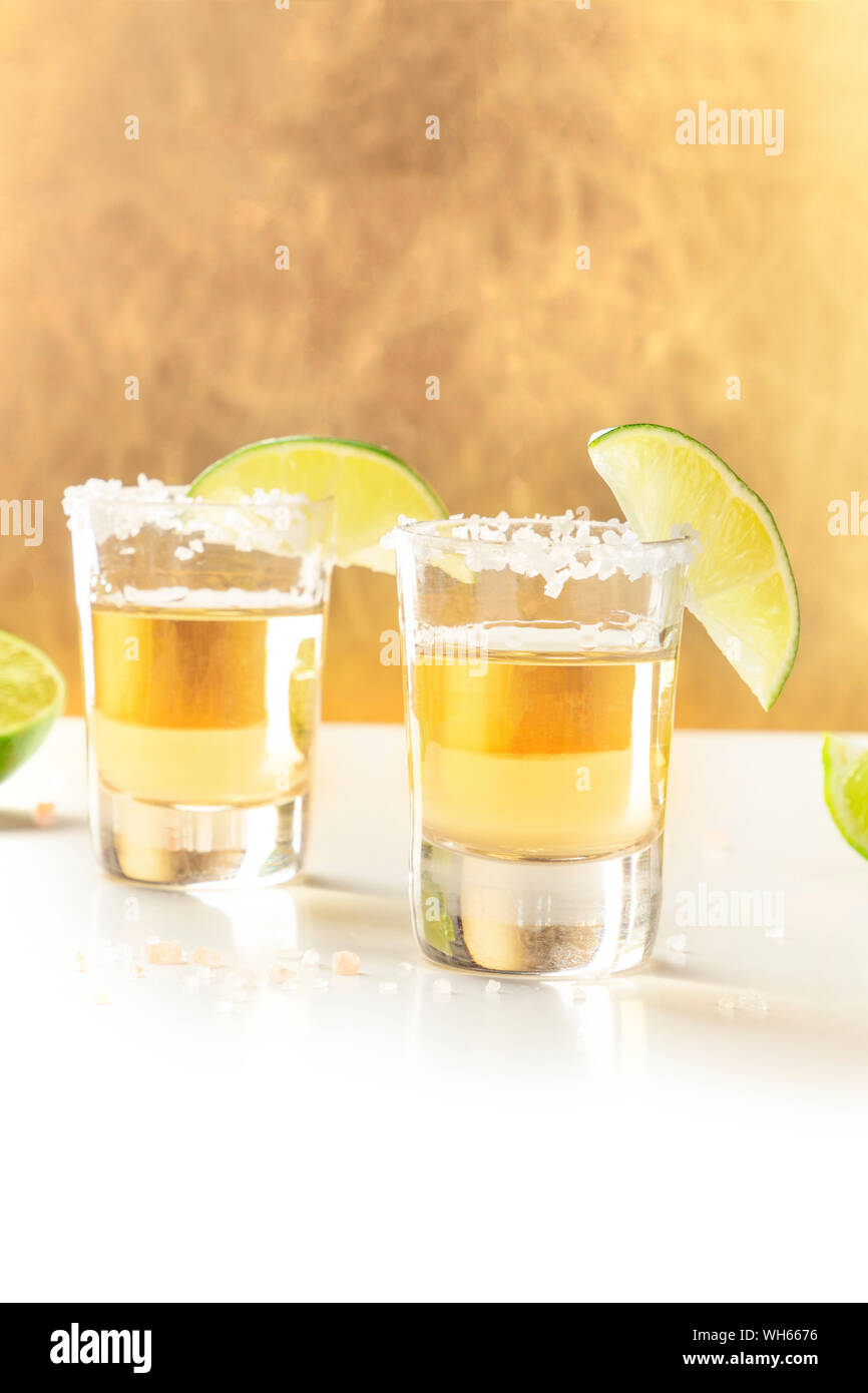 Golden tequila scatti con sale, fettine di lime e un posto per il testo Foto Stock