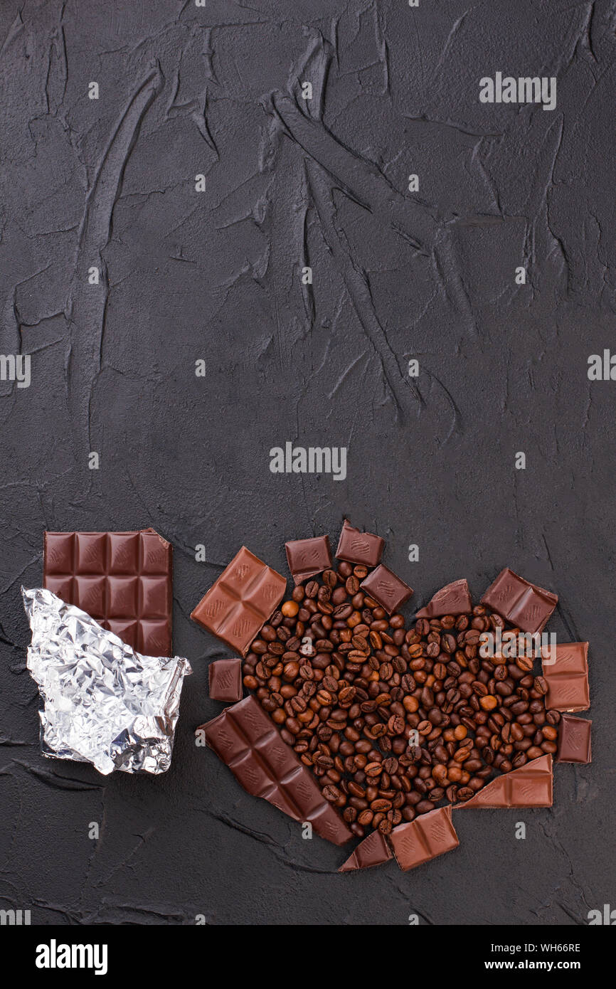 Barretta di cioccolato e cuore fatto da chicchi di caffè. Foto Stock