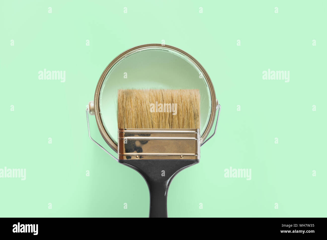 Nero con spazzola aperto può di menta di vernice sul neo Sfondo menta. Le riparazioni di tendenza concetto. Foto Stock