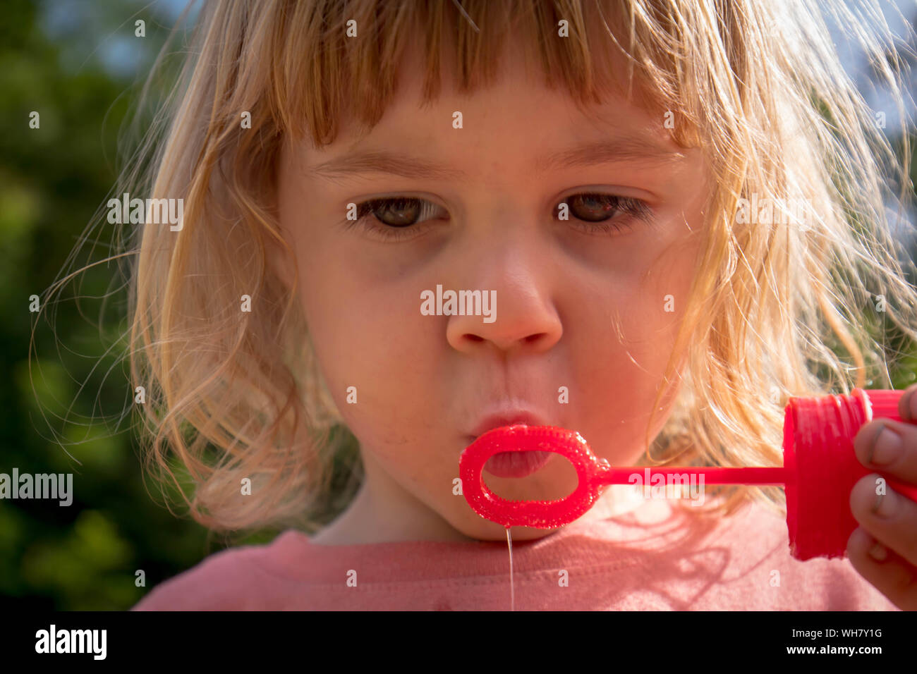 Bambino di 3 anni a soffiare bolle Foto Stock