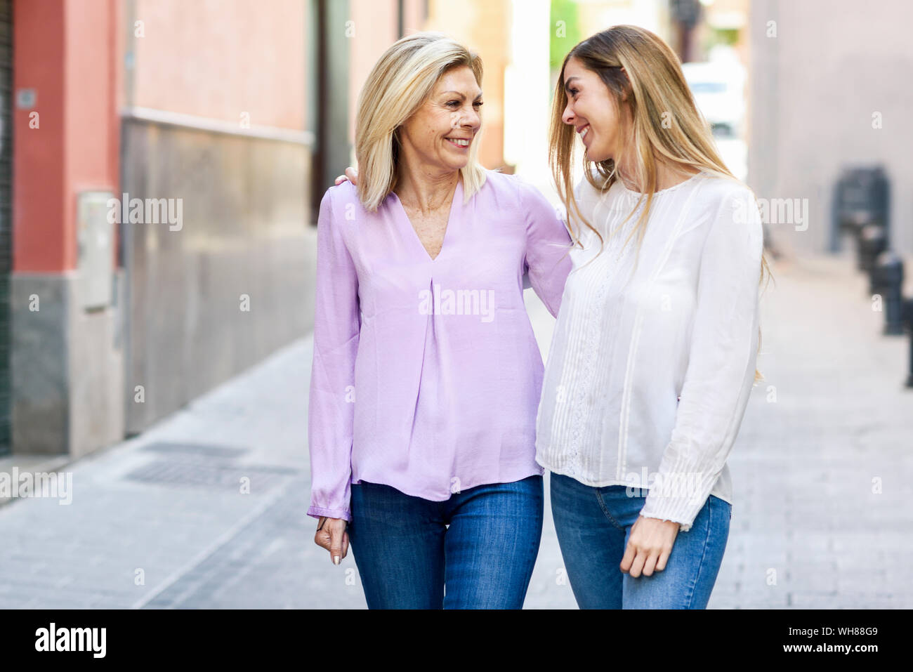 Felice donna matura a piedi con sua figlia in città Foto Stock