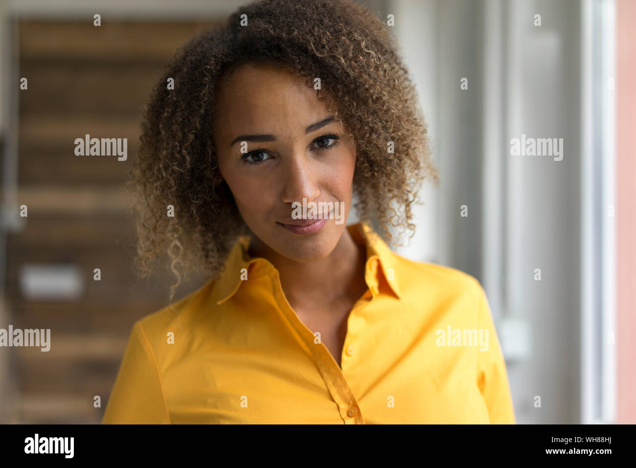 Ritratto di sorridente giovane donna indossa maglietta gialla Foto Stock