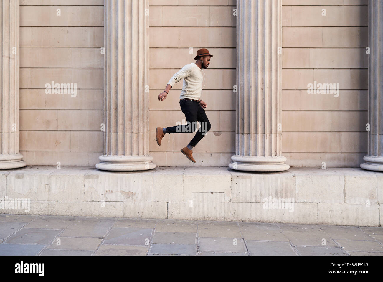 Metà uomo adulto ascoltando musica e jumping Foto Stock