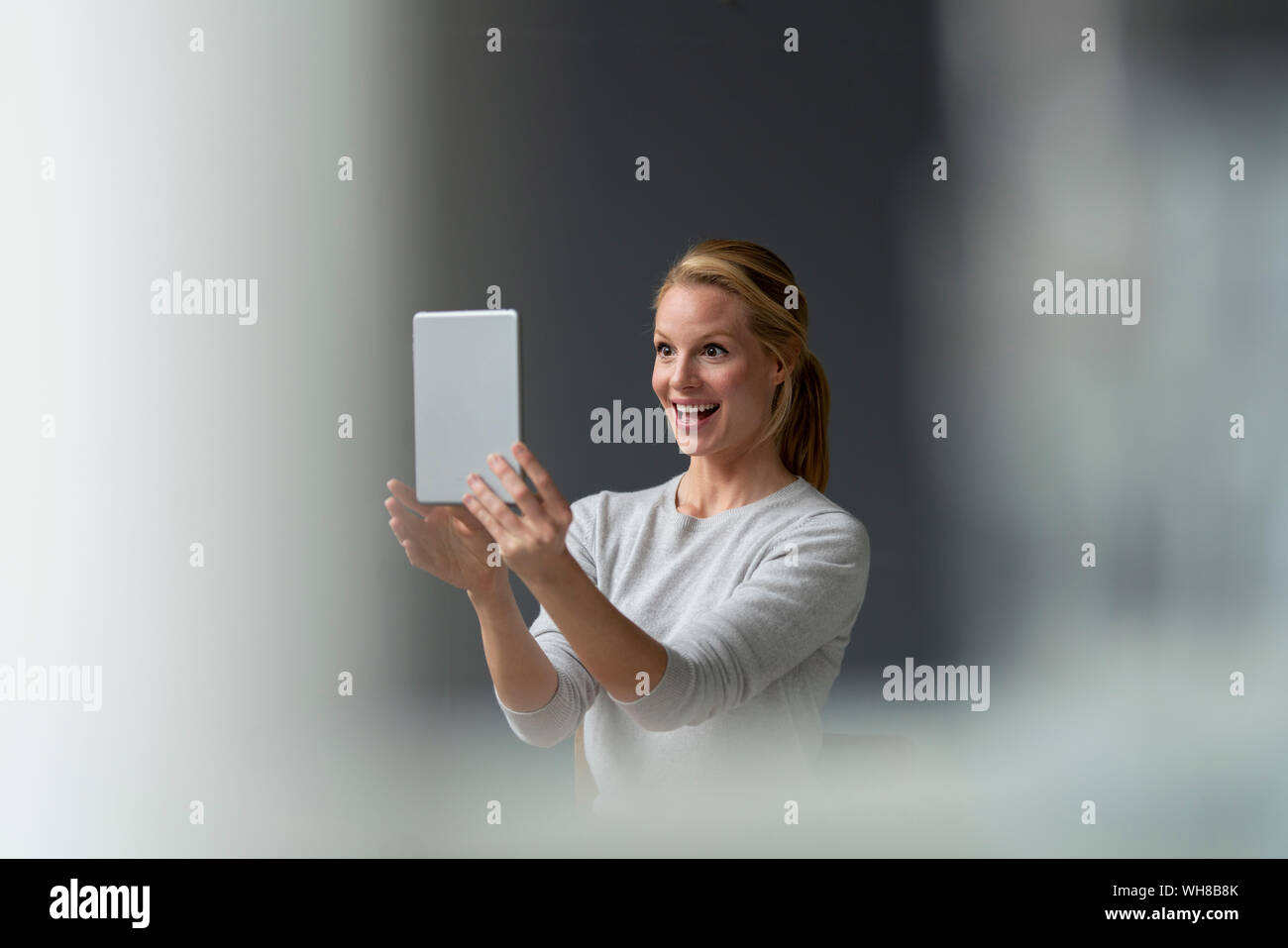 Felice giovane donna azienda tablet Foto Stock