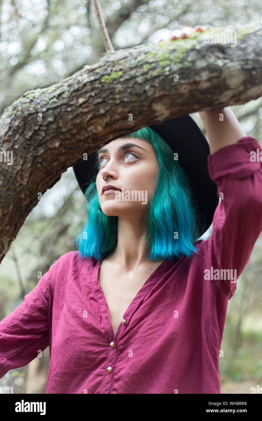 Ritratto di giovane donna con tinti di blu e verde per i capelli e piercing per il naso in natura Foto Stock