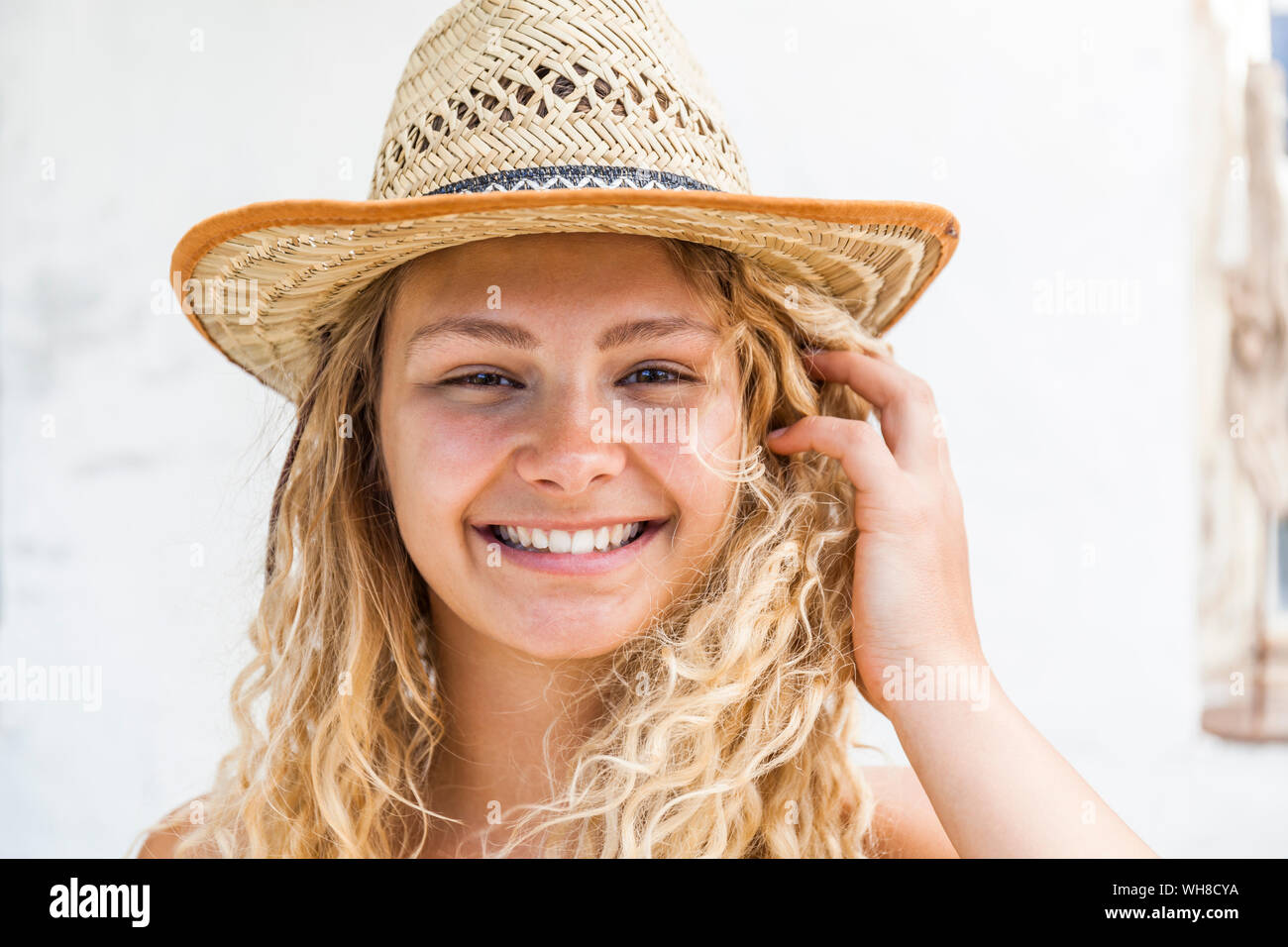 Ritratto di sorridere donna bionda che indossa cappello di paglia Foto Stock