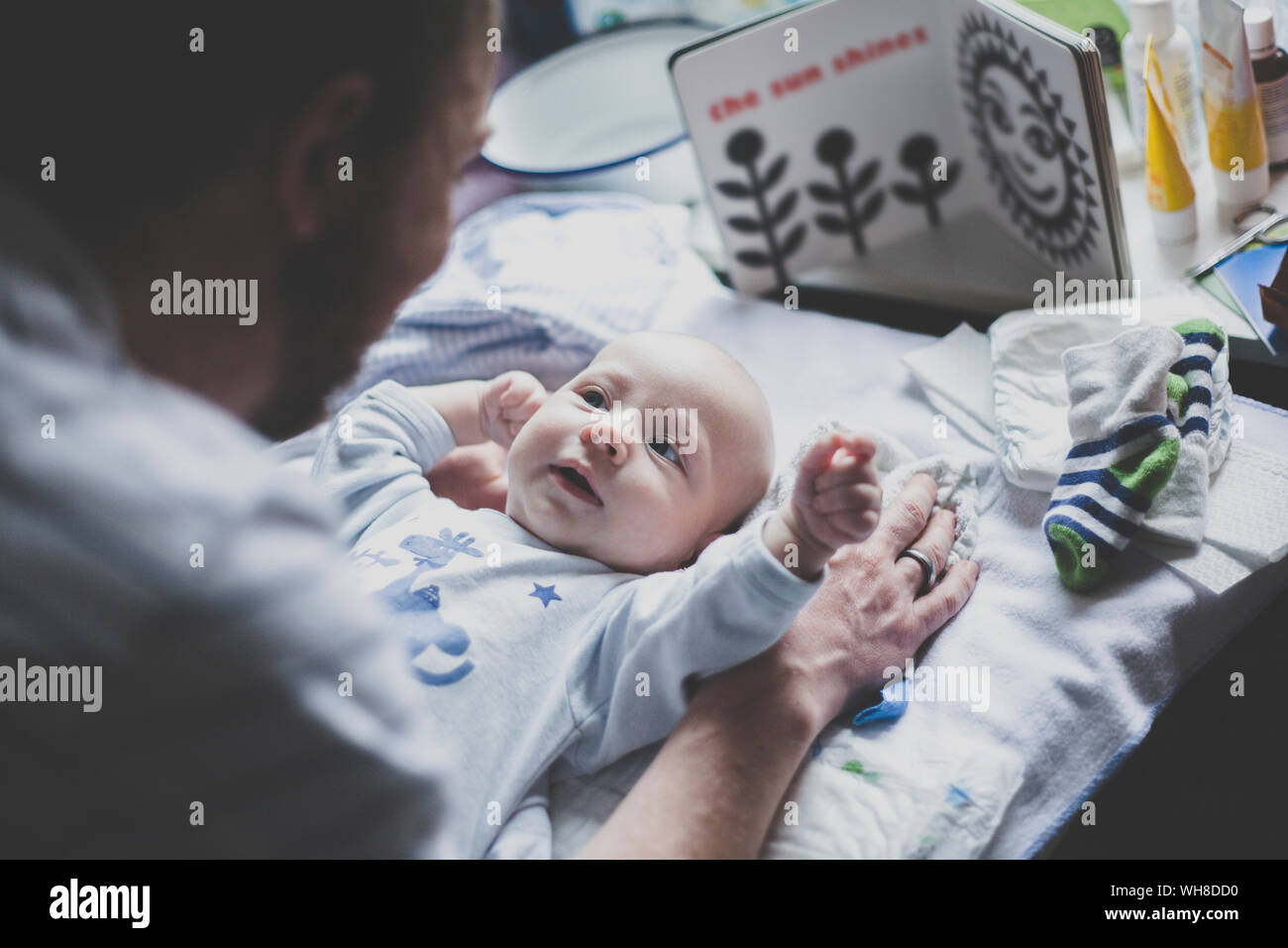 Padre giocando con il suo neonato figlio sulla modifica tabella Foto Stock