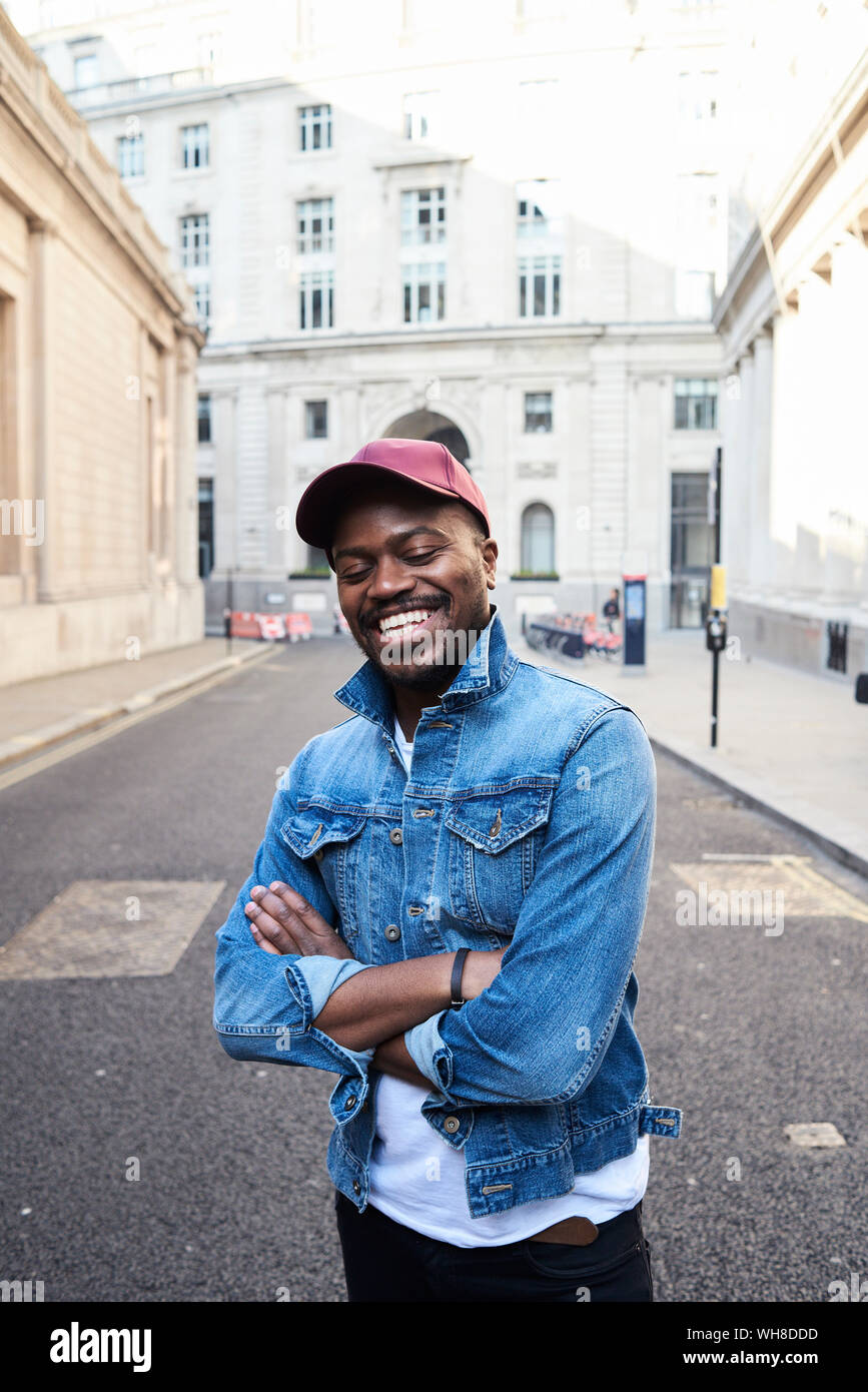 Ritratto di metà uomo adulto indossando giacca denim e basecap Foto Stock