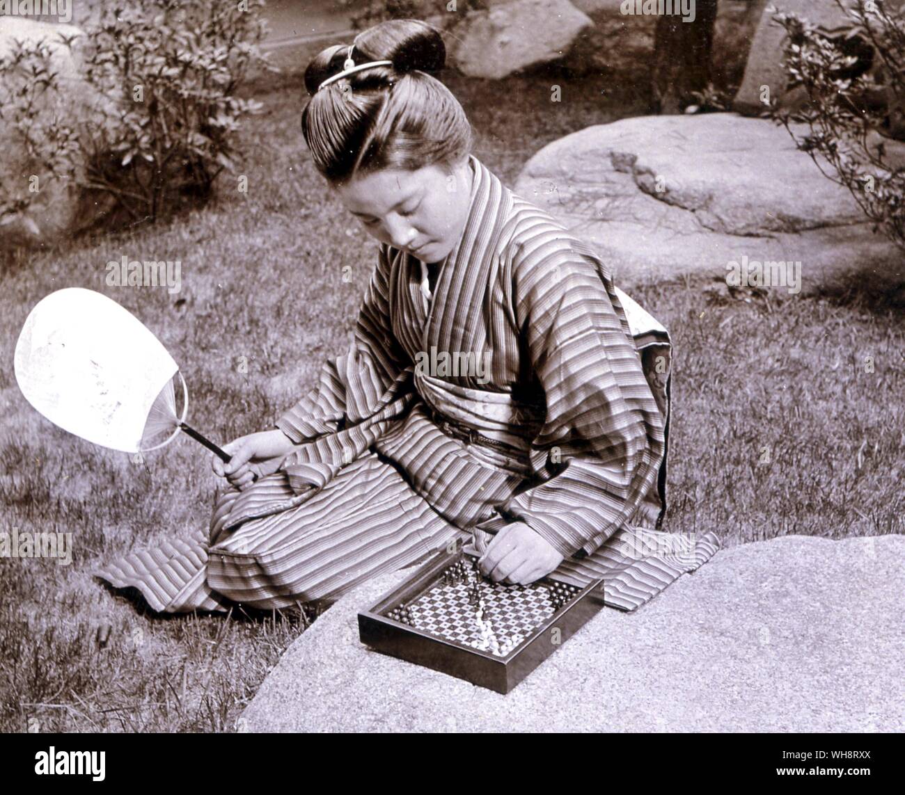 Donna Giapponese con un halma scheda. 1900. Foto Stock