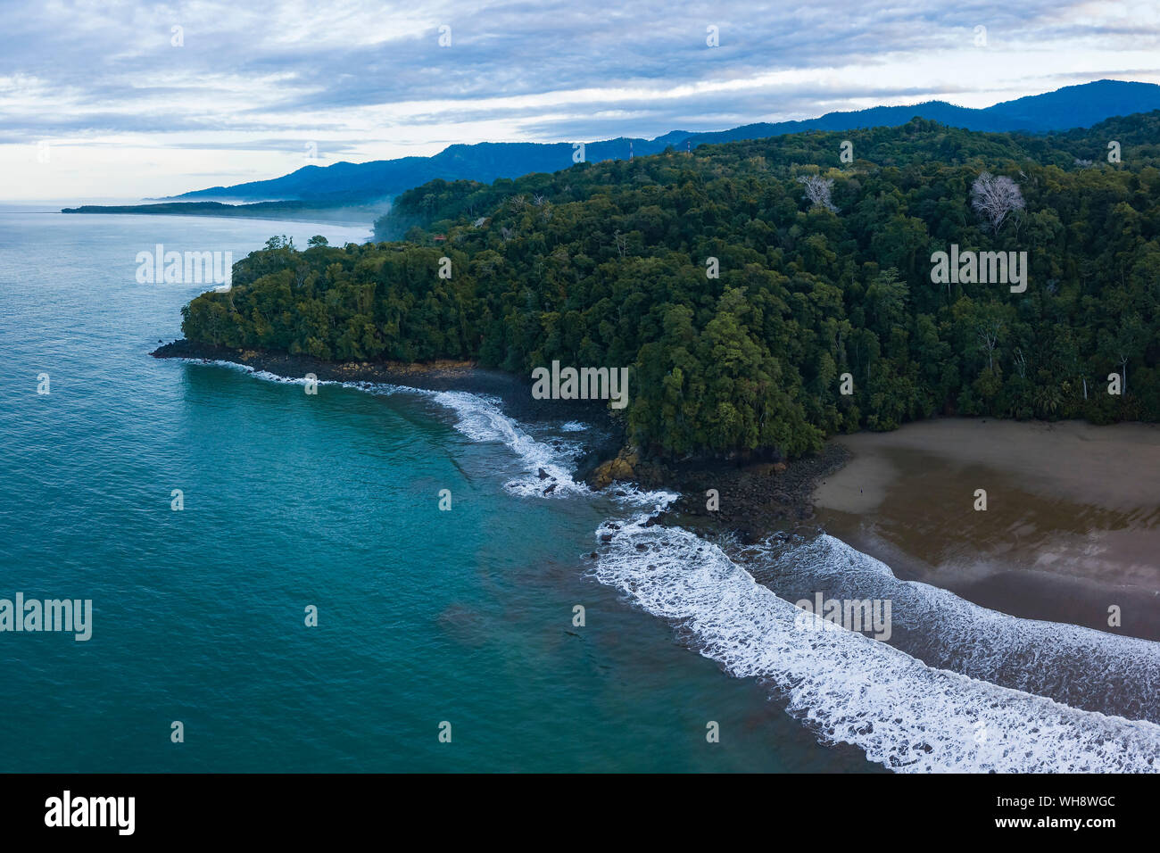 Drone vista della spiaggia di Arco e la foresta pluviale di sunrise, Uvita, Puntarenas Provincia, costa del Pacifico di Costa Rica, America Centrale Foto Stock