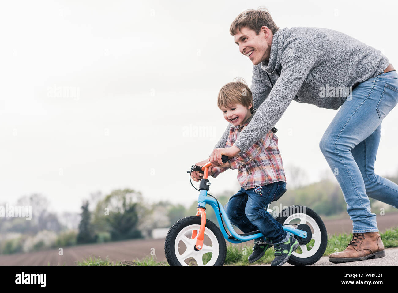 Insegnamento di padre di suo figlio come un giro in bicicletta, all'aperto Foto Stock