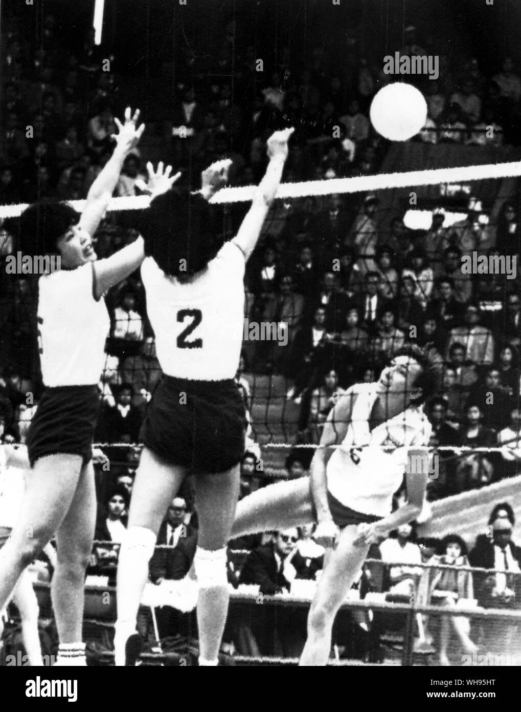 Giappone Tokyo Olimpiadi 1964: femminile di pallavolo tra il Giappone e la Polonia. Il Giappone Miyamoto (#2) e Matsunura (#5) leap per bloccare un colpo da della Polonia Kordaczeuk.. Foto Stock