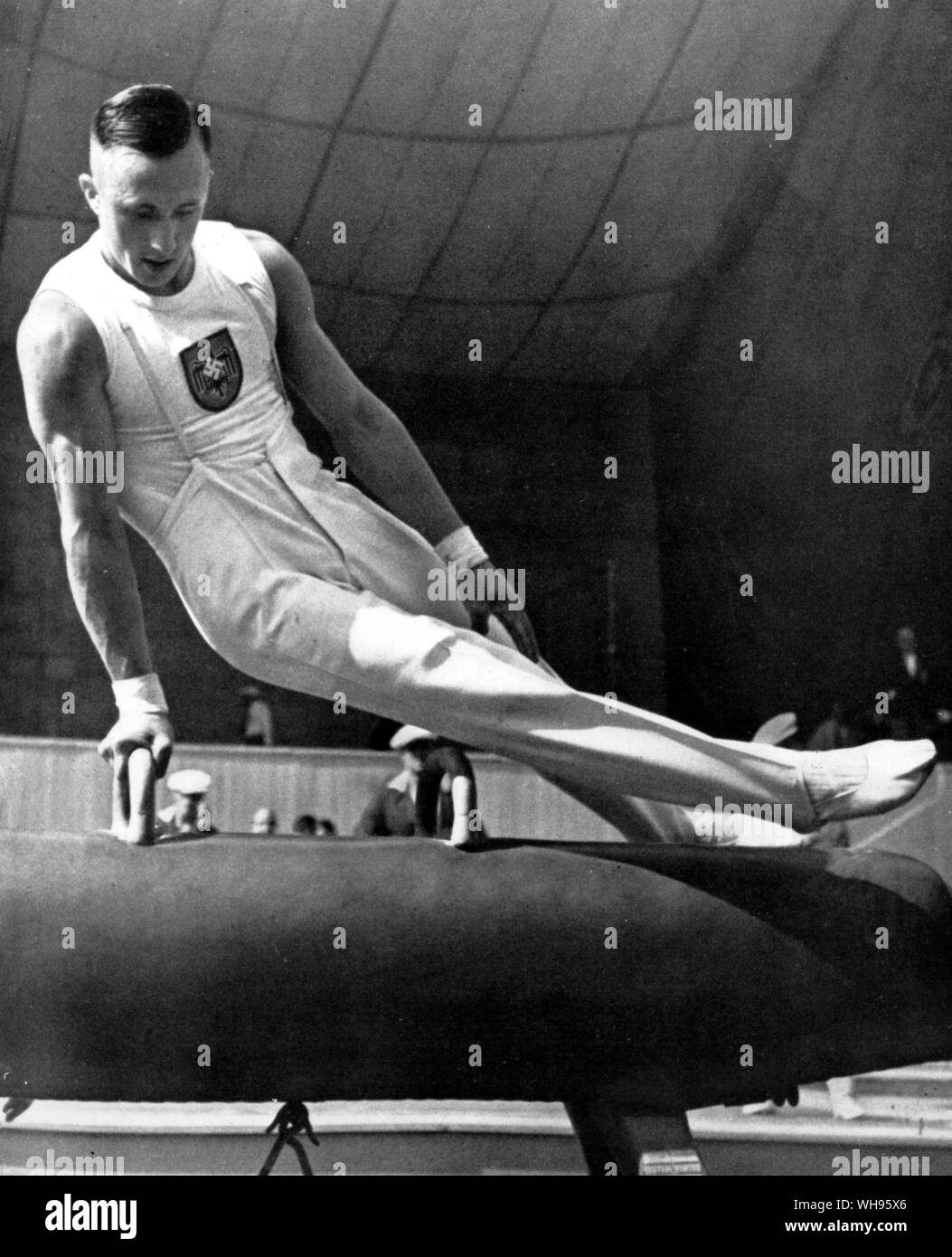 Alfred Schwarzmann (Germania) victor nel 12 concorso evento eseguendo la forbice sul cavallo pommelled presso i Giochi Olimpici di Berlino 1936 Foto Stock