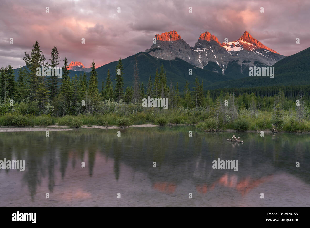 Tramonto e Alpenglow sui picchi di tre sorelle, Canmore, Alberta, Canadian Rockies, Canada, America del Nord Foto Stock