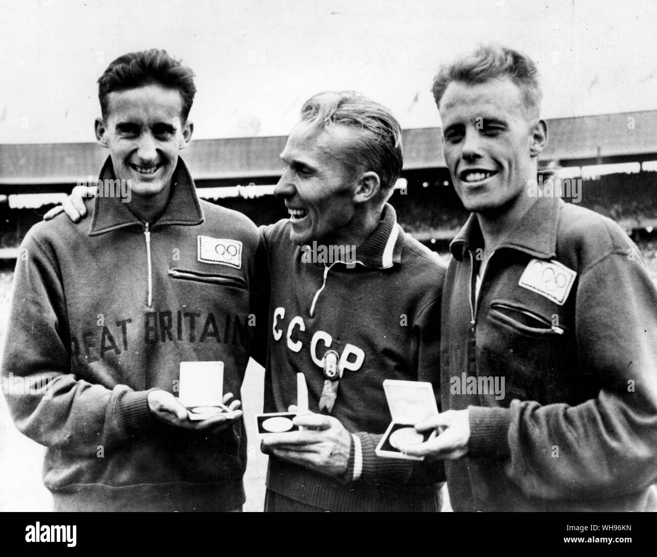 Aus., Melbourne, Olimpiadi, 1956: Valdimir Kuts (centro, URSS) con la sua medaglia d'oro per i suoi 5000 metri di vincere, con Gordon Pine (sinistra, Gran Bretagna) e Derek Ibbotson (destra, Gran Bretagna). Foto Stock