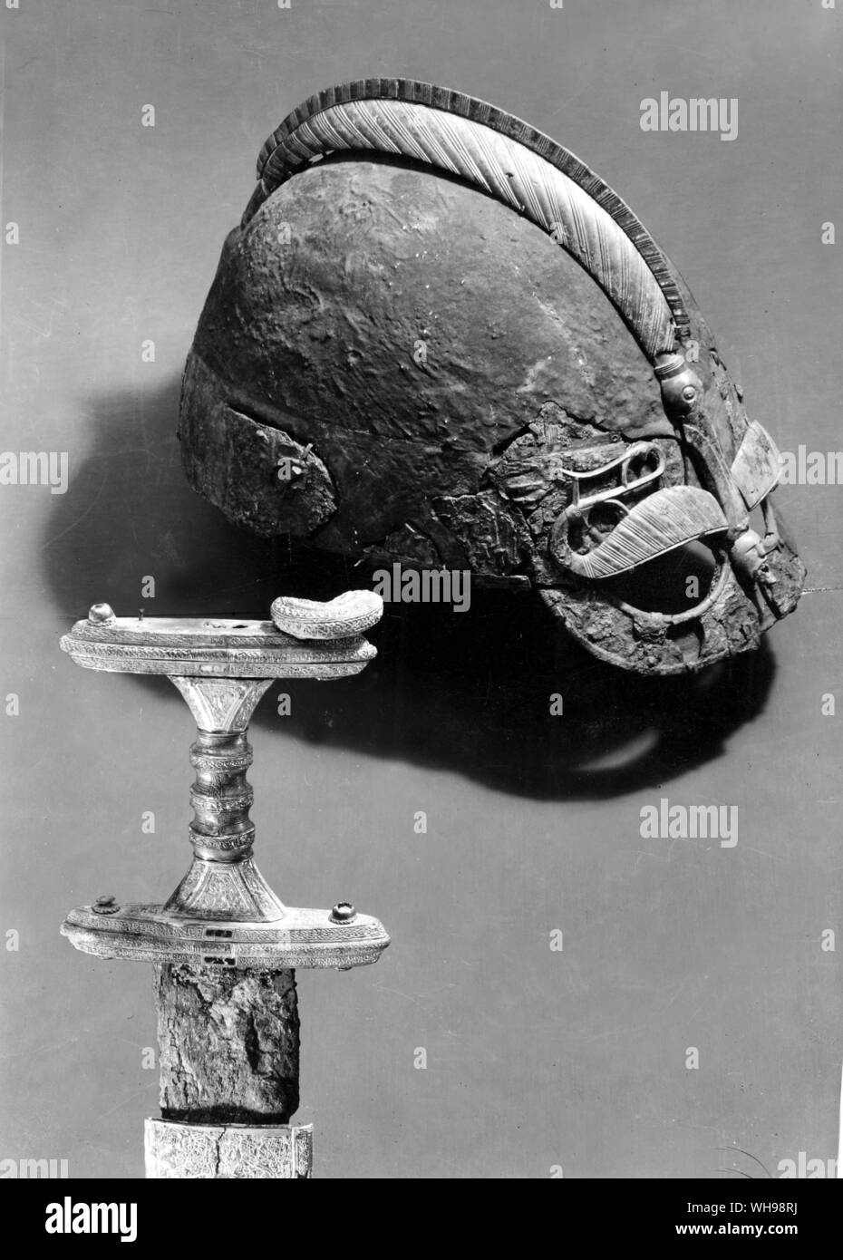 Antica warfare: casco e la spada di un soldato ad atti vandalici, probabilmente nel V secolo. Foto Stock