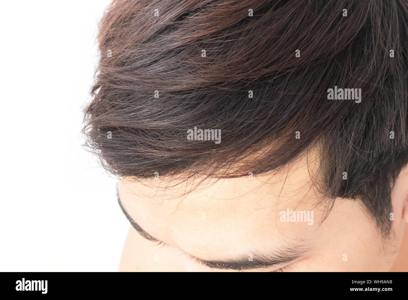 Immagine ritagliata dell uomo con i capelli neri contro uno sfondo bianco Foto Stock