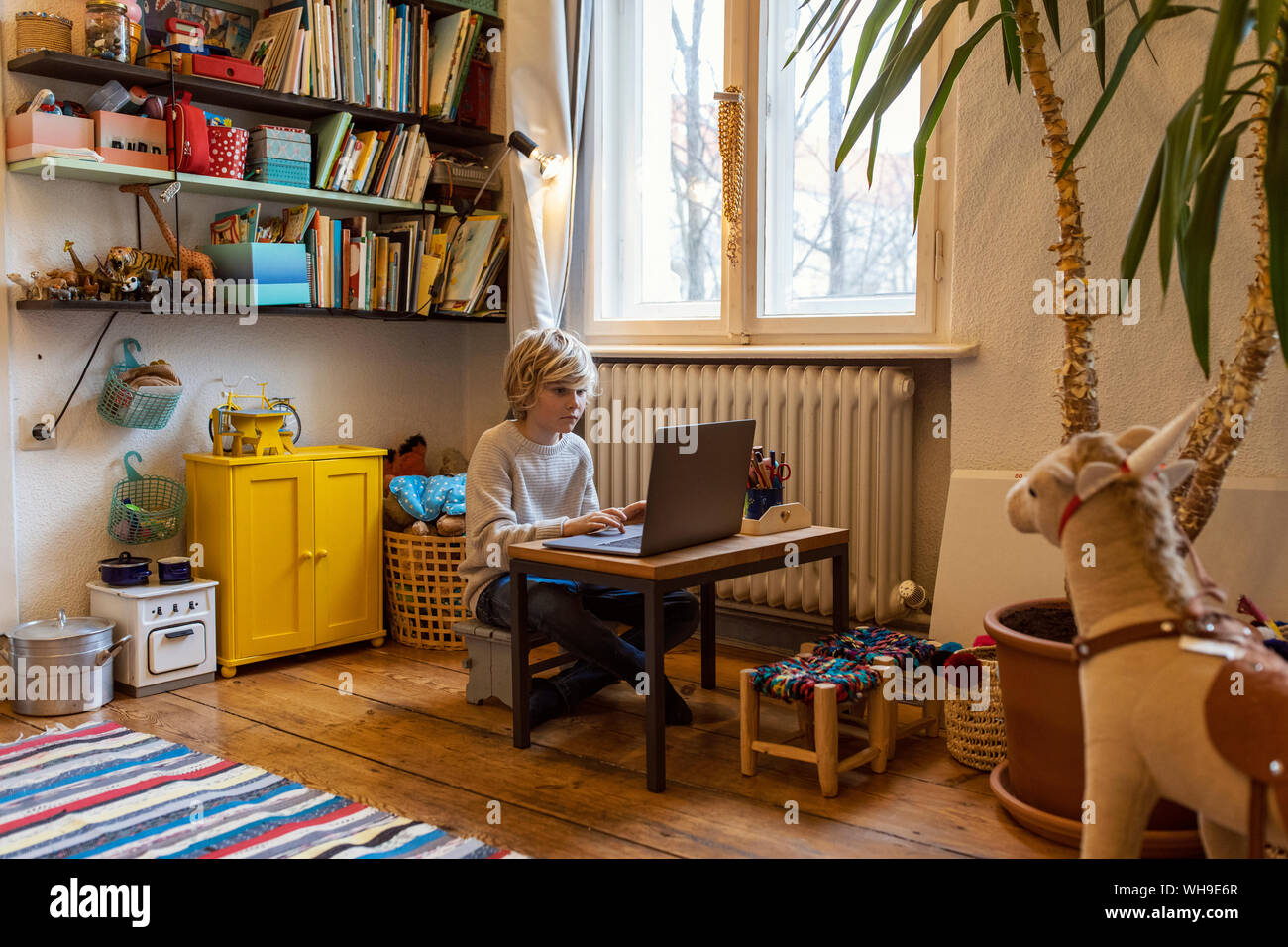 Boy utilizzando laptop nella sua stanza a casa Foto Stock