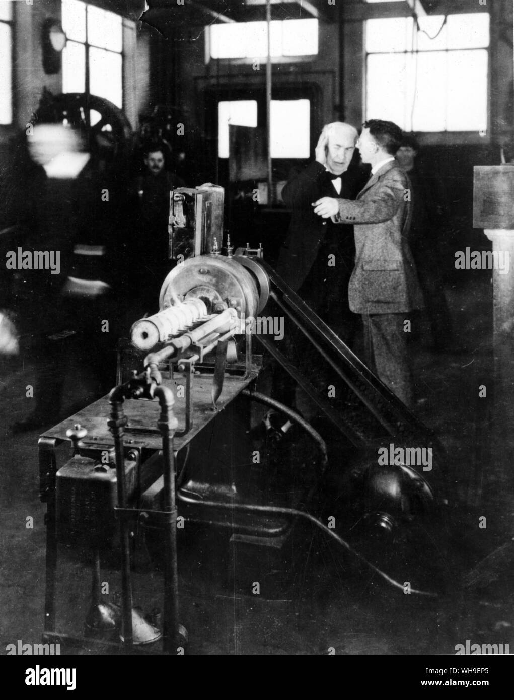 Thomas a Edison (1847-1931), noi lo scienziato e inventore in occasione di una visita alla General Electric Research Laboratory di Schenectady, New York in 1914. Dr William Coolidge spiega, Assistente direttore, spiega come il tungsteno viene realizzato per mezzo dell'apparecchiatura in primo piano. Foto Stock