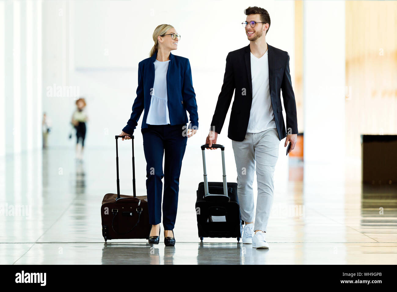Due giovani sorridenti business partner per camminare in aeroporto Foto Stock