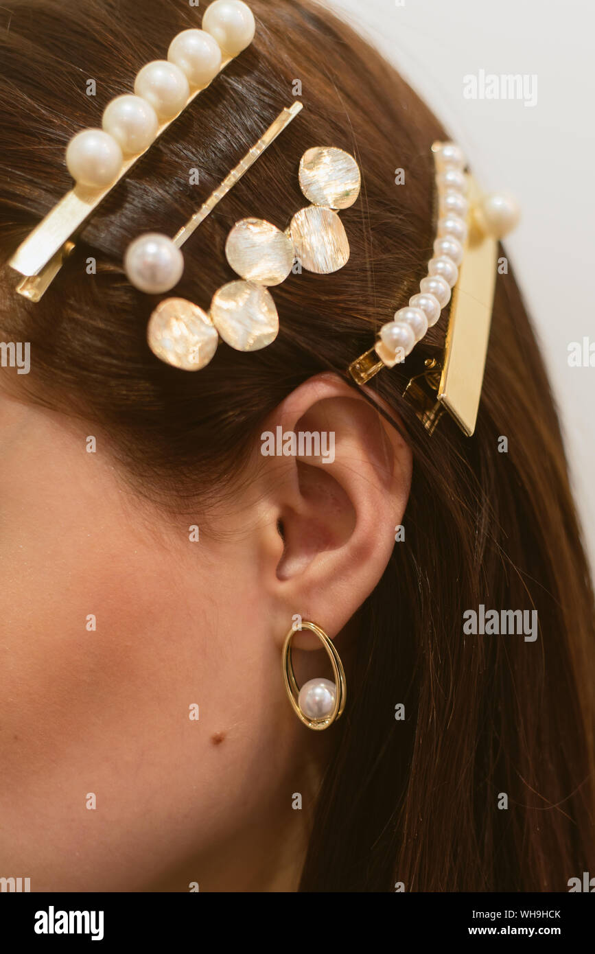 Elegante forcine per una ragazza dai capelli scuri. Orecchini perla Foto Stock