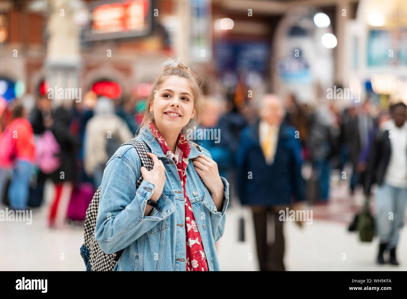 Sorridente giovane donna alla stazione ferroviaria Foto Stock