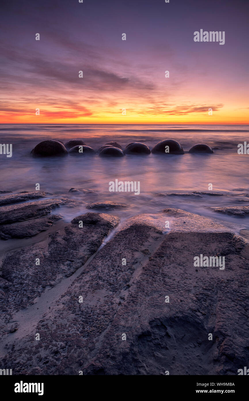 Epic alba alla spiaggia Moeraki con i massi Moeraki, Moeraki Beach, Otago, South Island, in Nuova Zelanda, Pacific Foto Stock