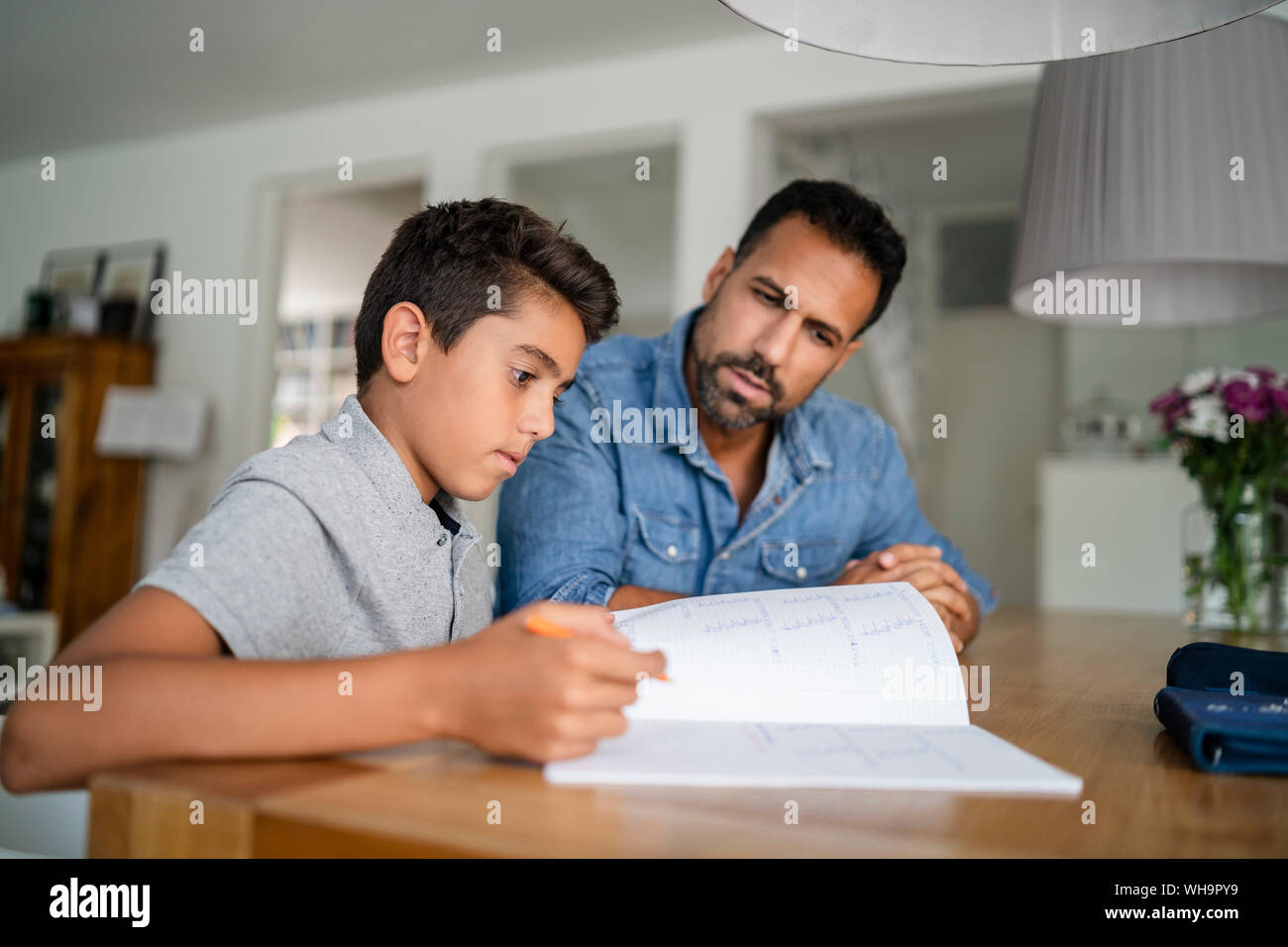 Padre aiutando figlio di fare i compiti di scuola Foto Stock