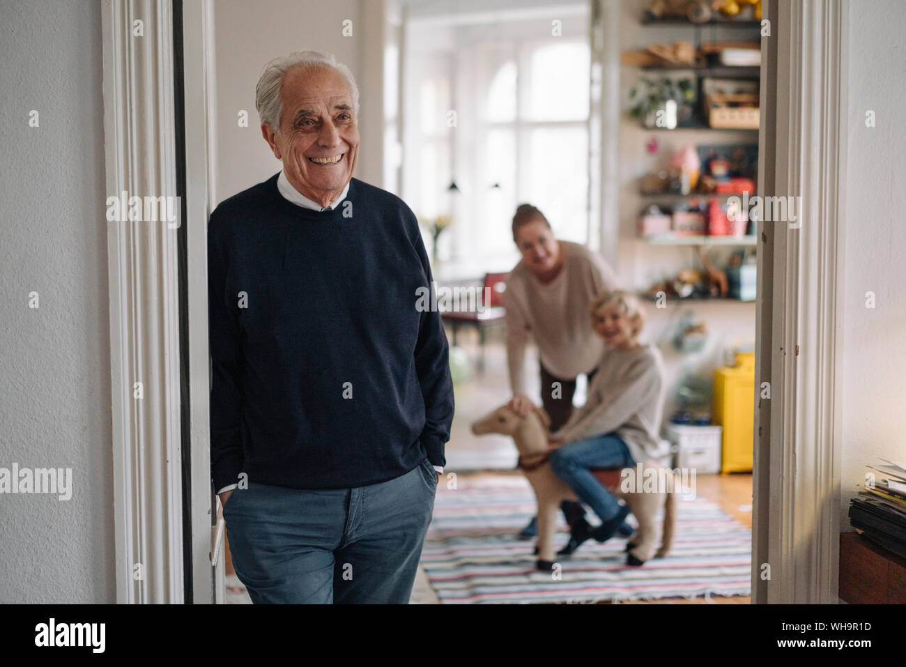 Nonno felice con la moglie e il nipote in background a casa Foto Stock