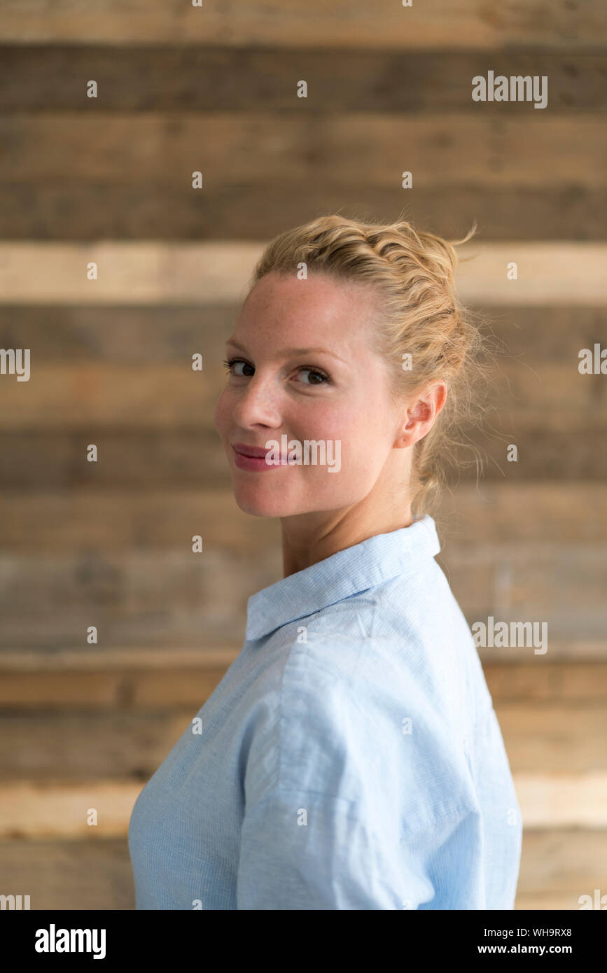 Ritratto di bella donna bionda, sullo sfondo di legno Foto Stock