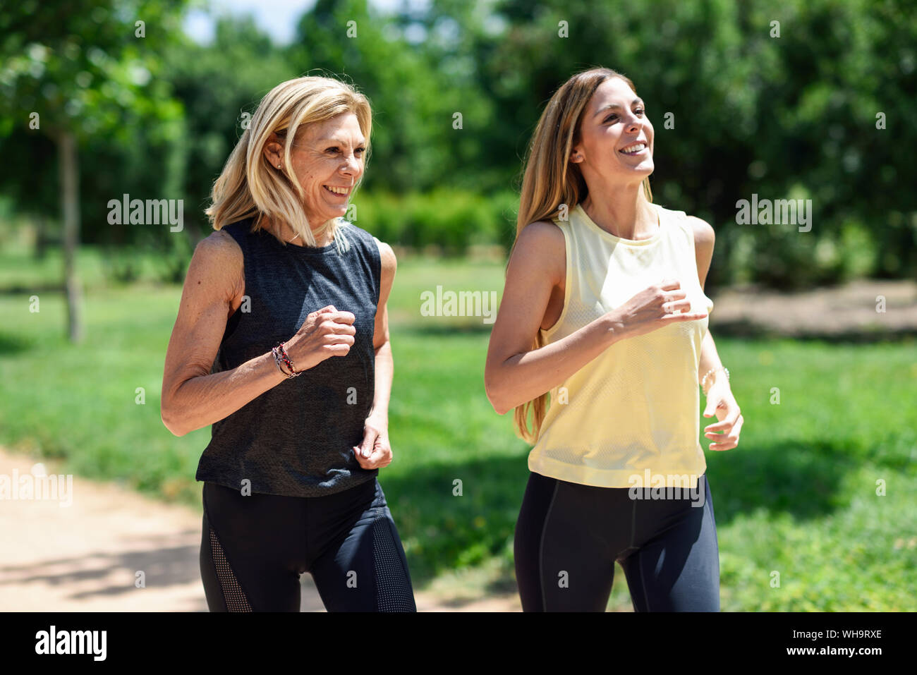 Donna matura in esecuzione con la figlia in un parco Foto Stock