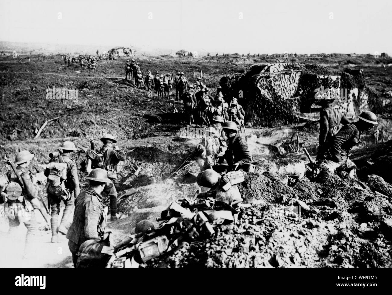 WW1/Francia: la Battaglia di legno del poligono. Mimetizzati serbatoi e movimento della fanteria fino all'attacco. Granata scoppia in distanza. Clapham Junction sul Menin Road a circa 3.5 miglia ad est di Ypres. 26 Sett. 1917 Foto Stock