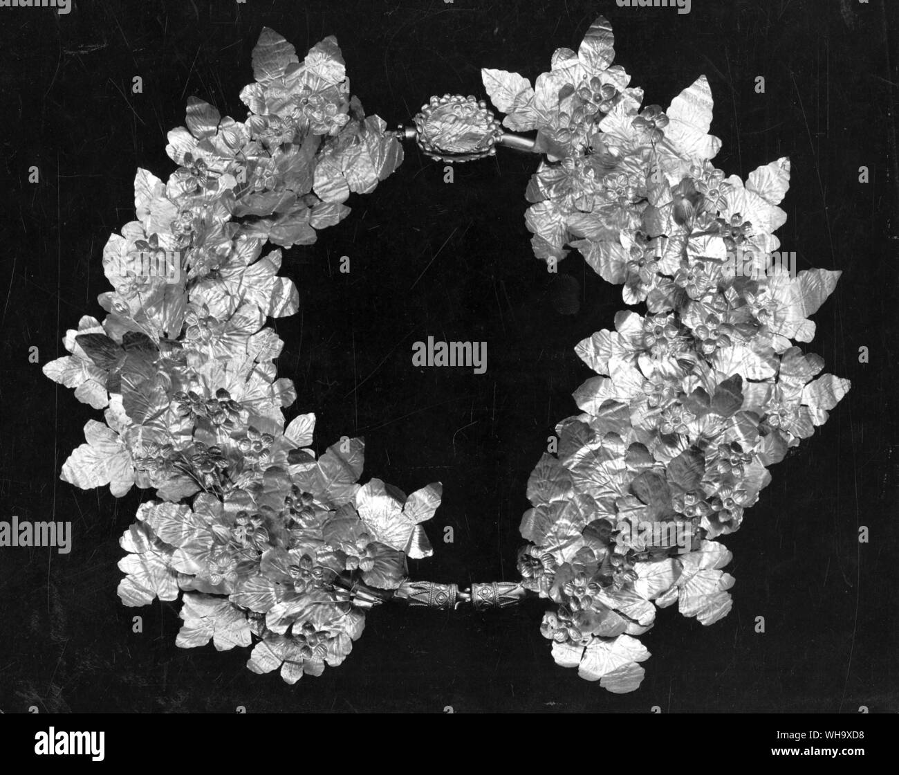 Strawberry-leaf wreath operatasi in oro con la delicatezza della natura. Foto Stock