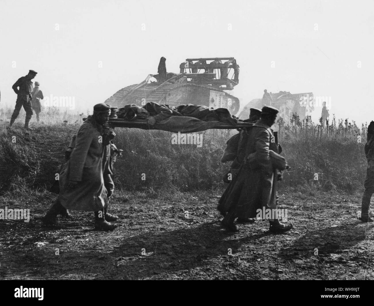 WW1: la Battaglia di San Quintino Canal. Prigionieri portando in . i feriti e Mark V serbatoi andando avanti con culle sul loro tetti per essere utilizzati in attraversamento della linea Hindenburg. Nei pressi di Bellicourt, Sett. 1918. Foto Stock