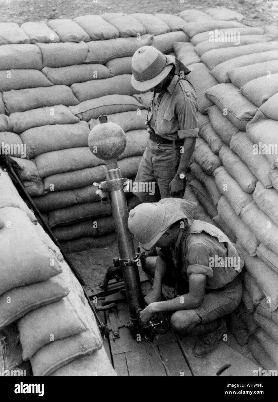 WW1: truppe alleate. Gli uomini indossano pastiglie per colonna vertebrale preparare un Ordnance M.L.2 pollici trincea mortaio mark ho per azione, 1918. Foto Stock