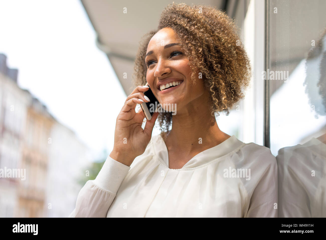 Ritratto di felice giovane donna al telefono Foto Stock