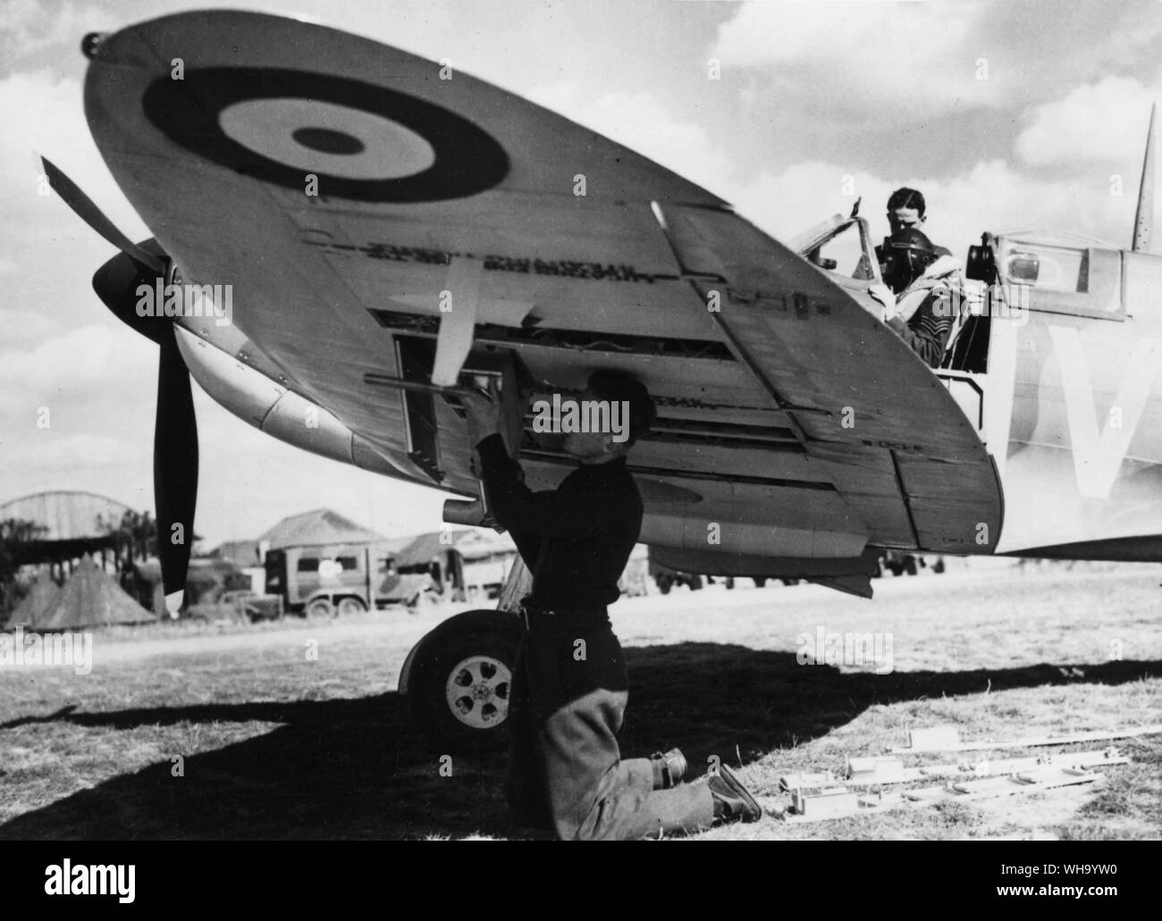 WW2/ battaglia della Gran Bretagna: Spitfire Squadron. Un armourer ri-bracci una Spitfire per ulteriori azioni, mentre il pilota ha una parola con il meccanico. RAF Foto Stock