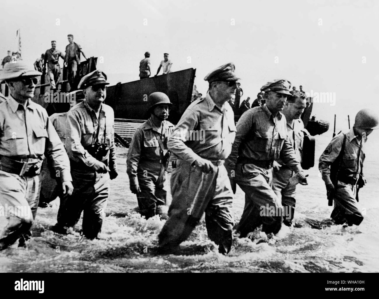 WW2: General Douglas MacArthur guadare attraverso l'acqua dal Landing Craft per tornare alle Filippine. Accompagnato dal suo Capo di Stato Maggiore, Lt. Generale Sutherland e dagli alti funzionari. Il presidente Sergio Osmana anche in shot (indossando il casco di sughero di estrema sinistra). Foto Stock