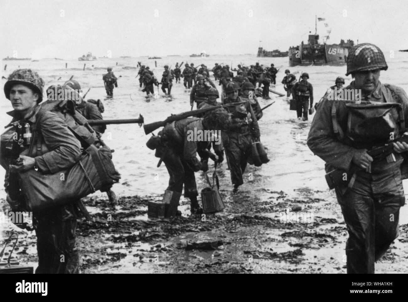 WW2: American truppe di shock che trasportano attrezzatura completa wade alla testa di ponte nel nord della Francia durante lo sbarco degli Alleati, 6 giugno 1944. D giorno. Foto Stock