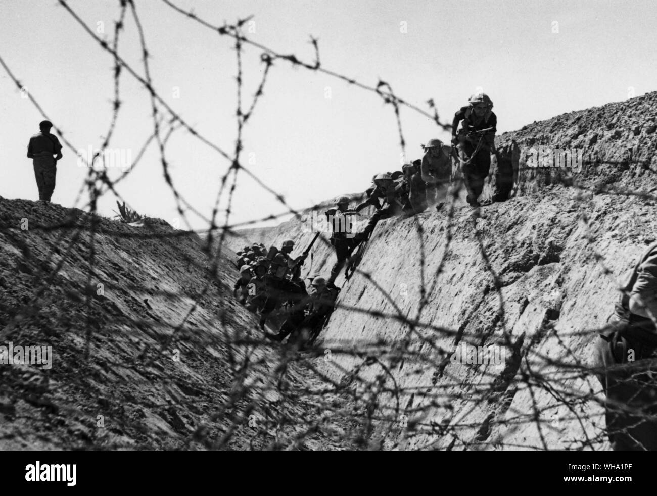 WW2: Gli uomini del 9° Battaglione DLI (fanteria leggera Durham??) formare una piramide umana per scalare i fianchi di un anti-serbatoio fossa (12 Aprile 1943 - photo data di rilascio). Tunisia (?). Foto Stock